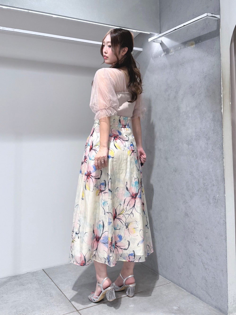 ピンク系のニット/セーター、ホワイト系のスカート、シルバー系のサンダルを着用したレディースの夏コーディネートの2枚目の写真