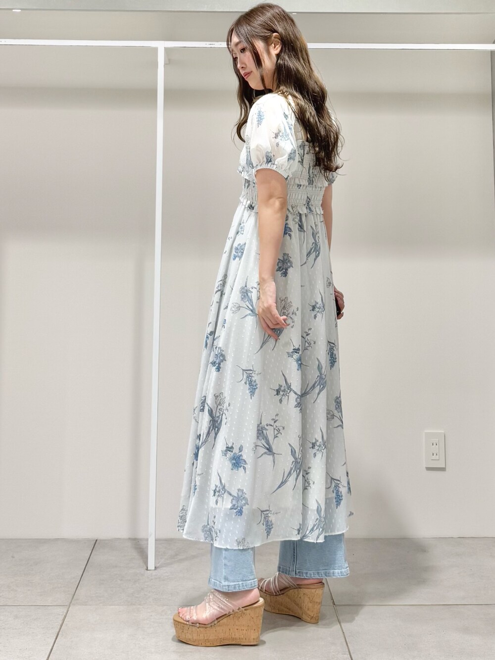 グレー系のワンピース、ブルー系のデニムパンツ、その他のサンダルを着用したレディースの春コーディネートの4枚目の写真