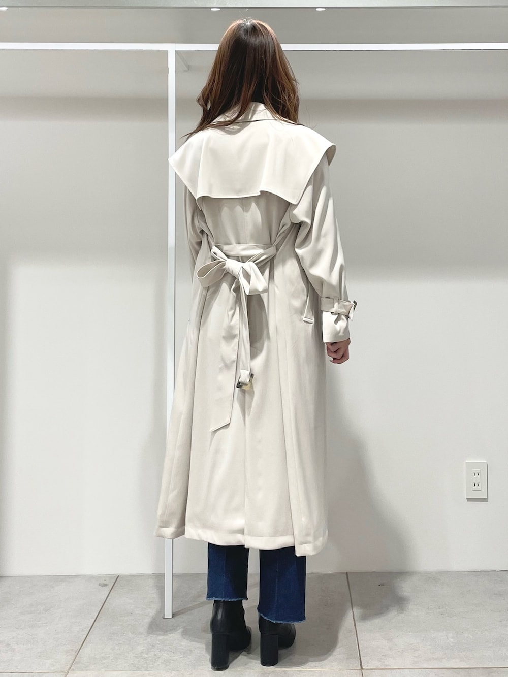 ホワイト系のハンドバッグ、ブラック系のブーツ、ブルー系のニット/セーターを着用したレディースの冬コーディネートの3枚目の写真