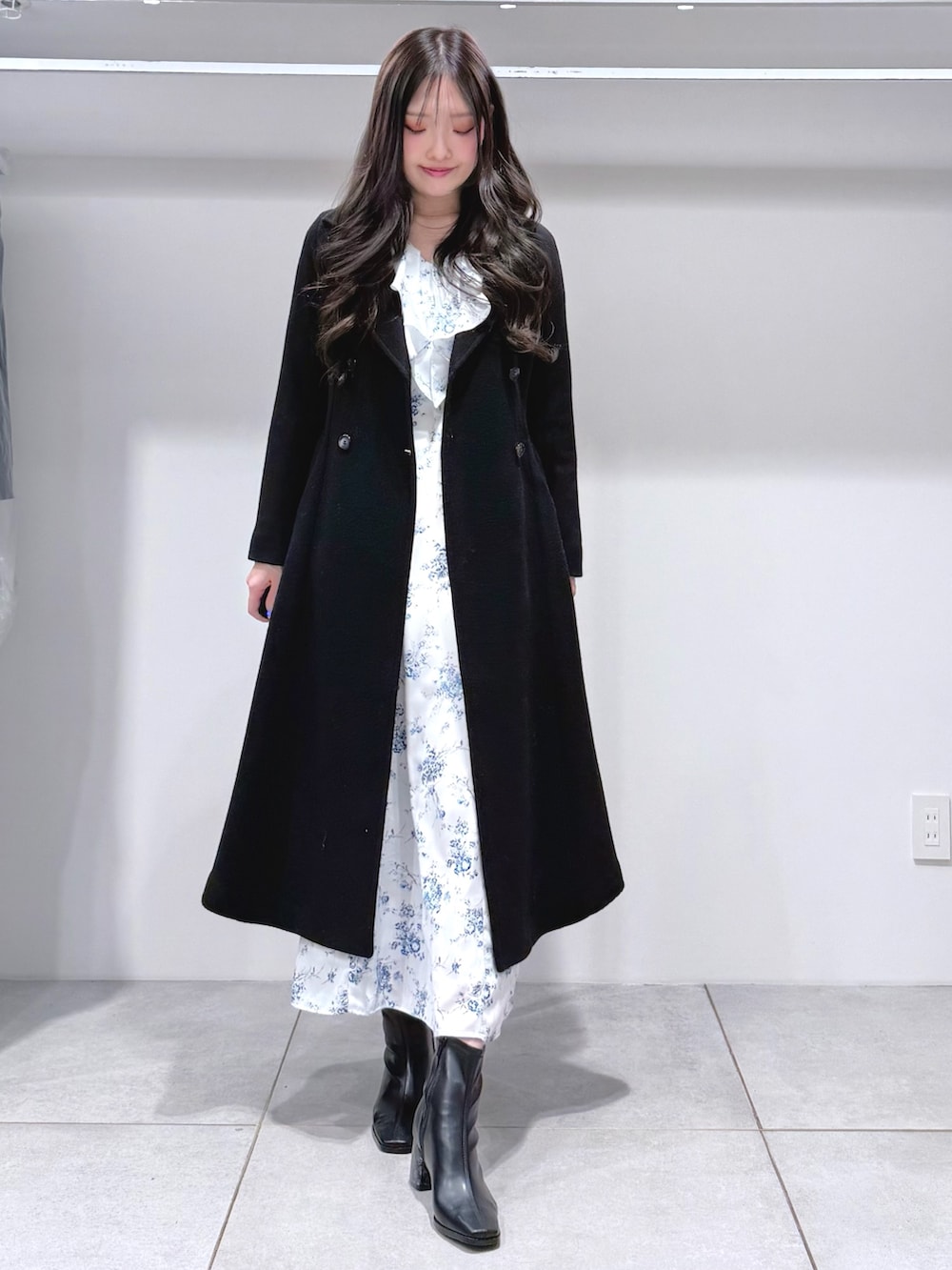 ブルー系のワンピース、ブラック系のブーツ、ブラック系のその他アウターを着用したレディースの冬コーディネートの2枚目の写真