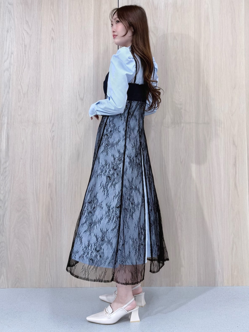 ブルー系のワンピース、ホワイト系のパンプスを着用したレディースの冬コーディネートの3枚目の写真