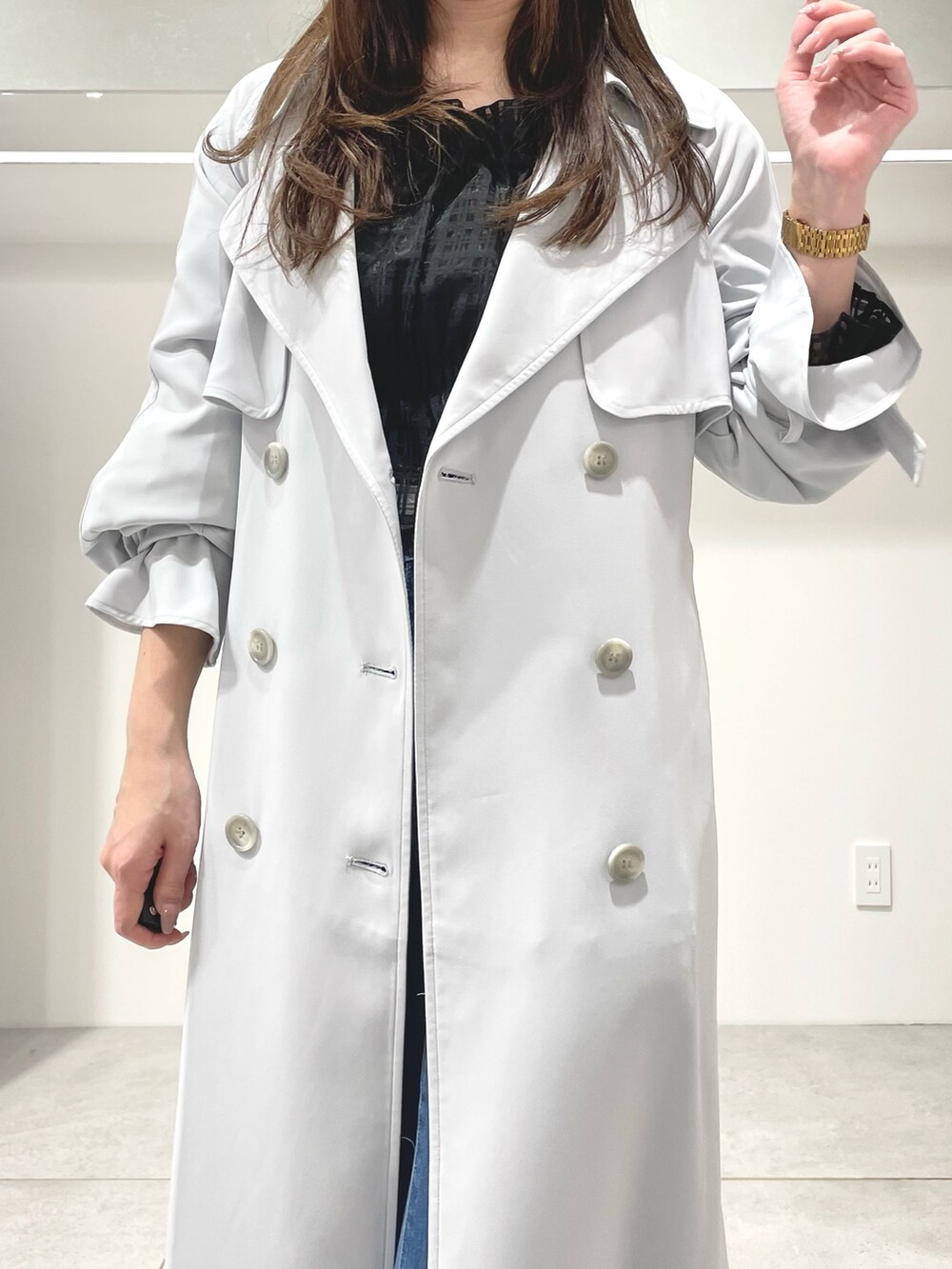 ブルー系のトレンチコート、ブルー系のデニムパンツ、ブラック系のブーツを着用したレディースの春コーディネートの3枚目の写真