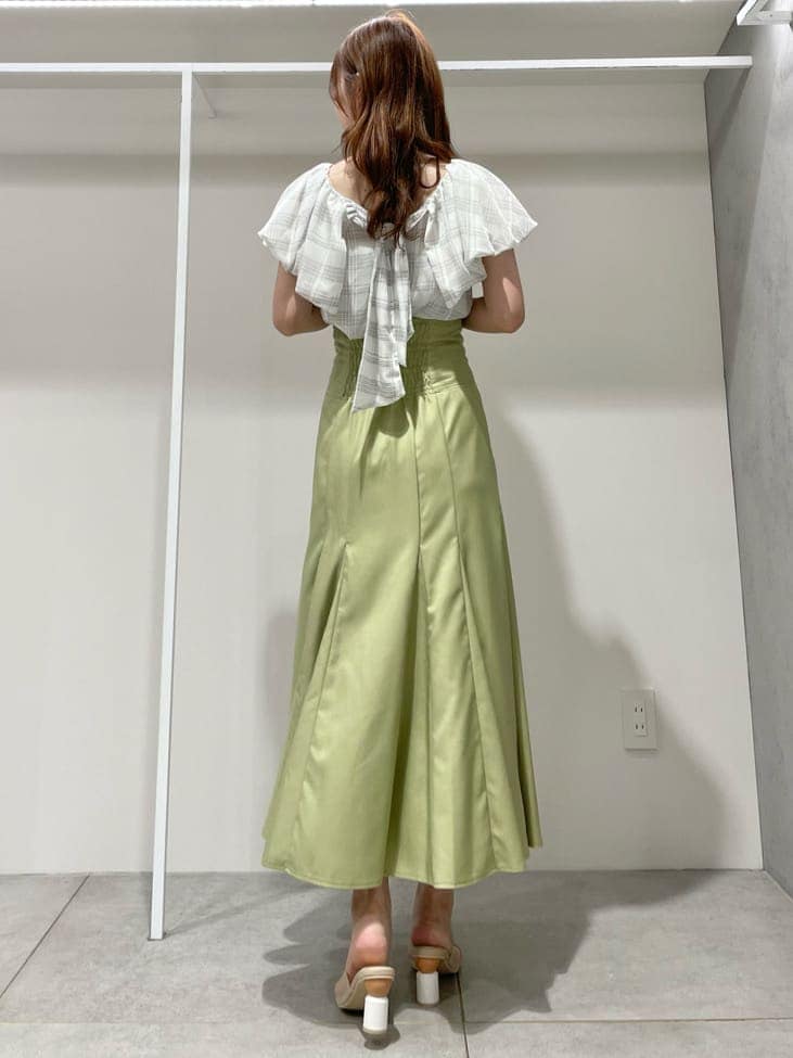 ホワイト系のキャミソール、グリーン系のスカート、ベージュ系のサンダルを着用したレディースの夏コーディネートの3枚目の写真