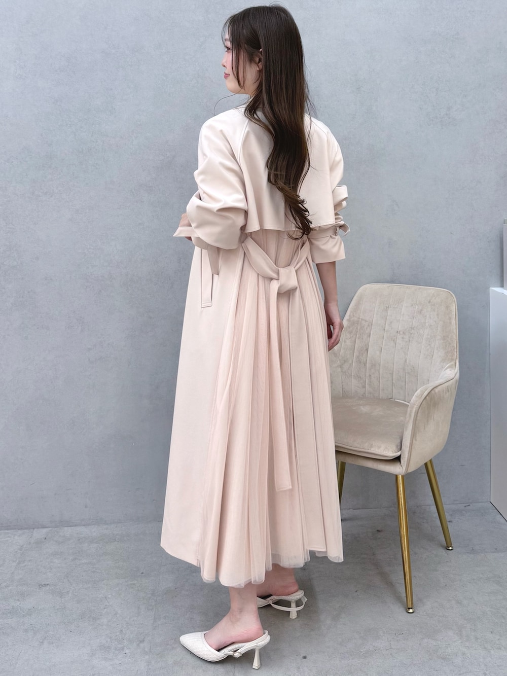 ホワイト系のワンピース、ピンク系のトレンチコート、ホワイト系のパンプスを着用したレディースの冬コーディネートの2枚目の写真