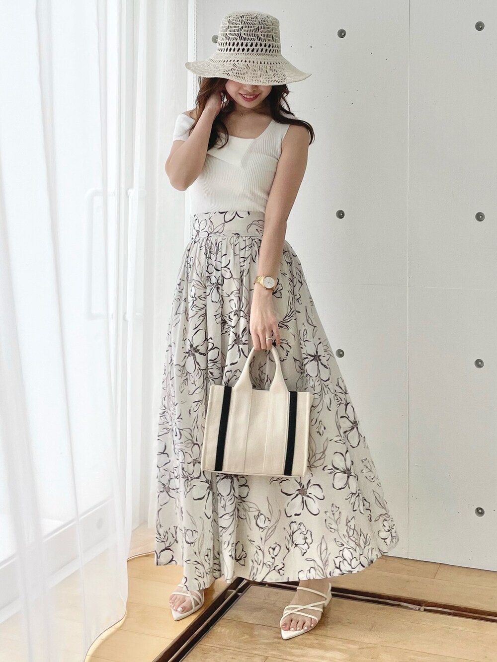 ホワイト系のニット/セーター、ホワイト系のスカート、ホワイト系のサンダルを着用したレディースの春コーディネートの2枚目の写真