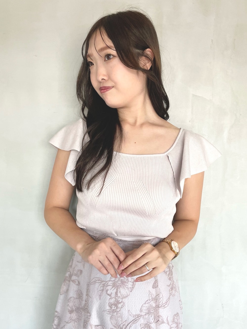 ピンク系のニット/セーター、ピンク系のスカート、ブラウン系のブーツを着用したレディースの春コーディネートの3枚目の写真