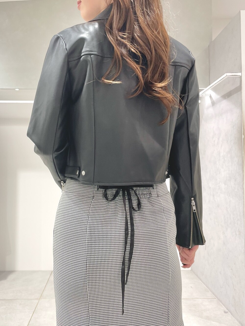 ブラック系のライダースジャケット、ブラック系のニット/セーター、その他のスカートを着用したレディースの秋コーディネートの5枚目の写真