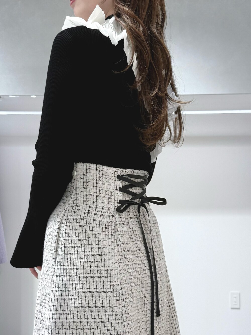 ブラック系のニット/セーター、ブラック系のハンドバッグ、ブラック系のブーツを着用したレディースの秋コーディネートの6枚目の写真