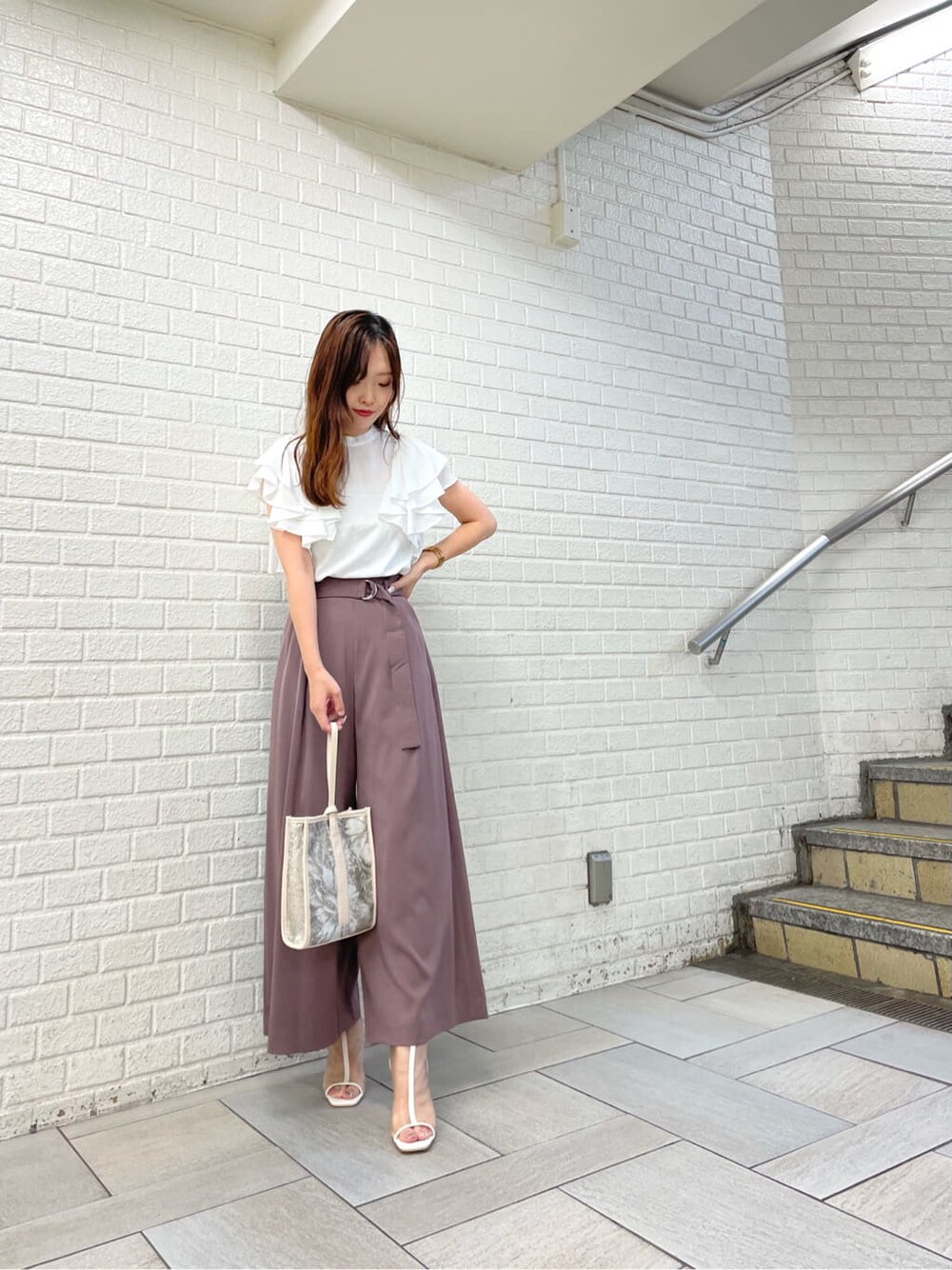 ホワイト系のその他シューズ、ホワイト系のシャツ/ブラウス、ベージュ系のハンドバッグを着用したレディースの秋コーディネートの2枚目の写真