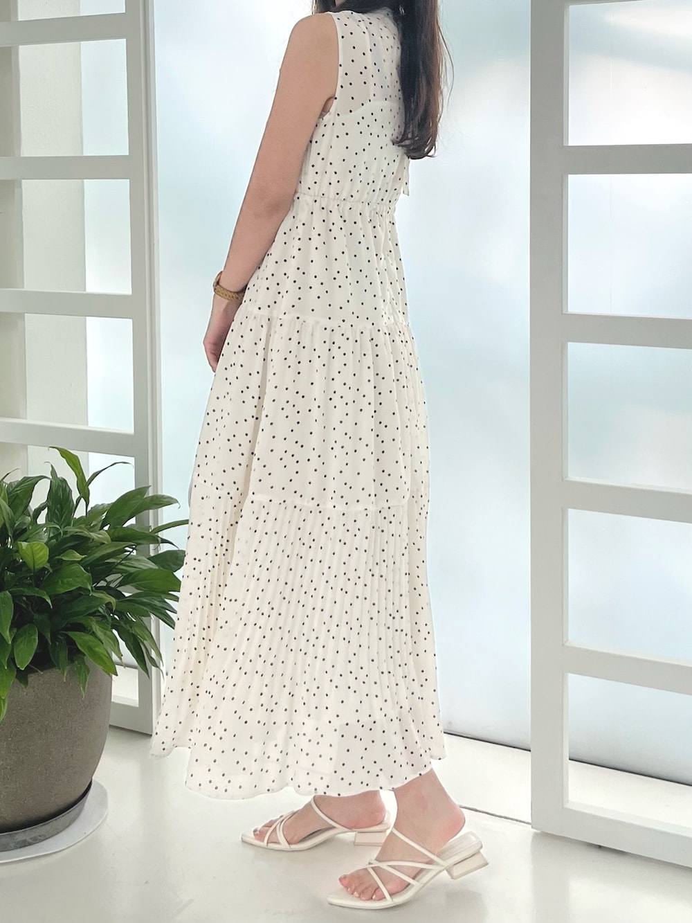 ホワイト系のワンピース、ブルー系のハンドバッグ、ホワイト系のサンダルを着用したレディースの夏コーディネートの2枚目の写真