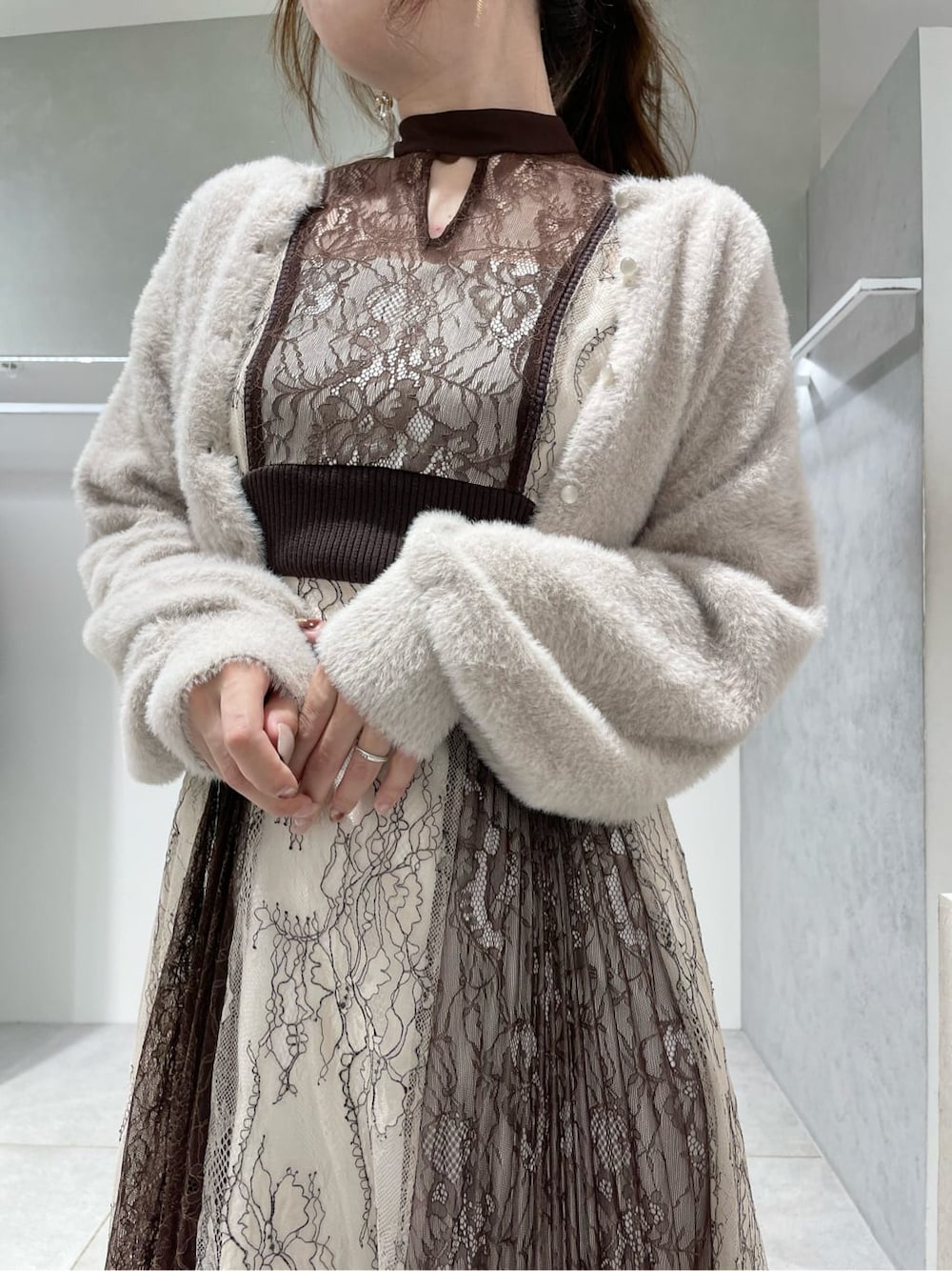 ブラック系のパンプス、ホワイト系のワンピース、ベージュ系のカーディガン/ボレロを着用したレディースの秋コーディネートの3枚目の写真