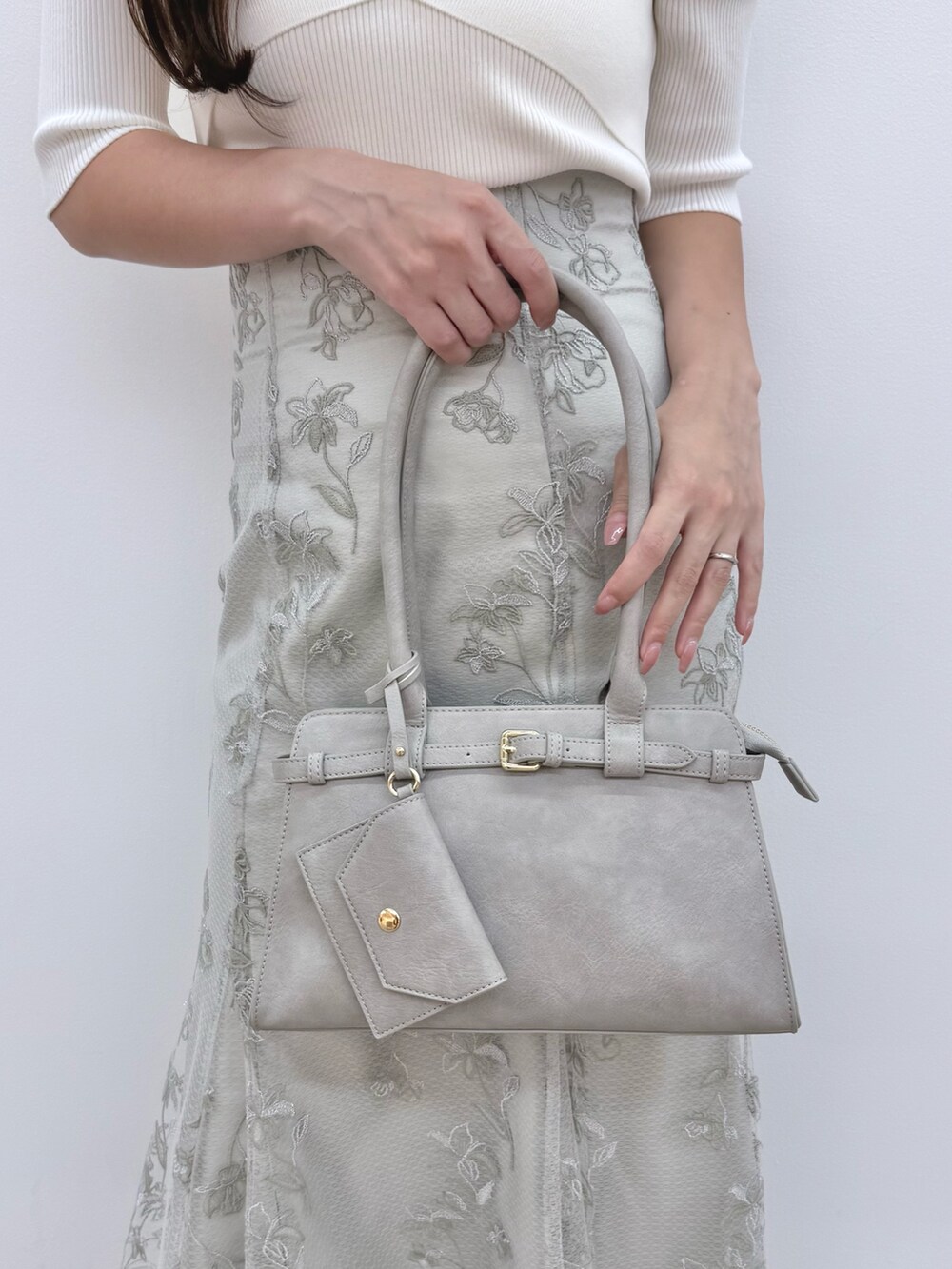 ホワイト系のニット/セーター、ホワイト系のブーツ、グリーン系のスカートを着用したレディースの秋コーディネートの6枚目の写真