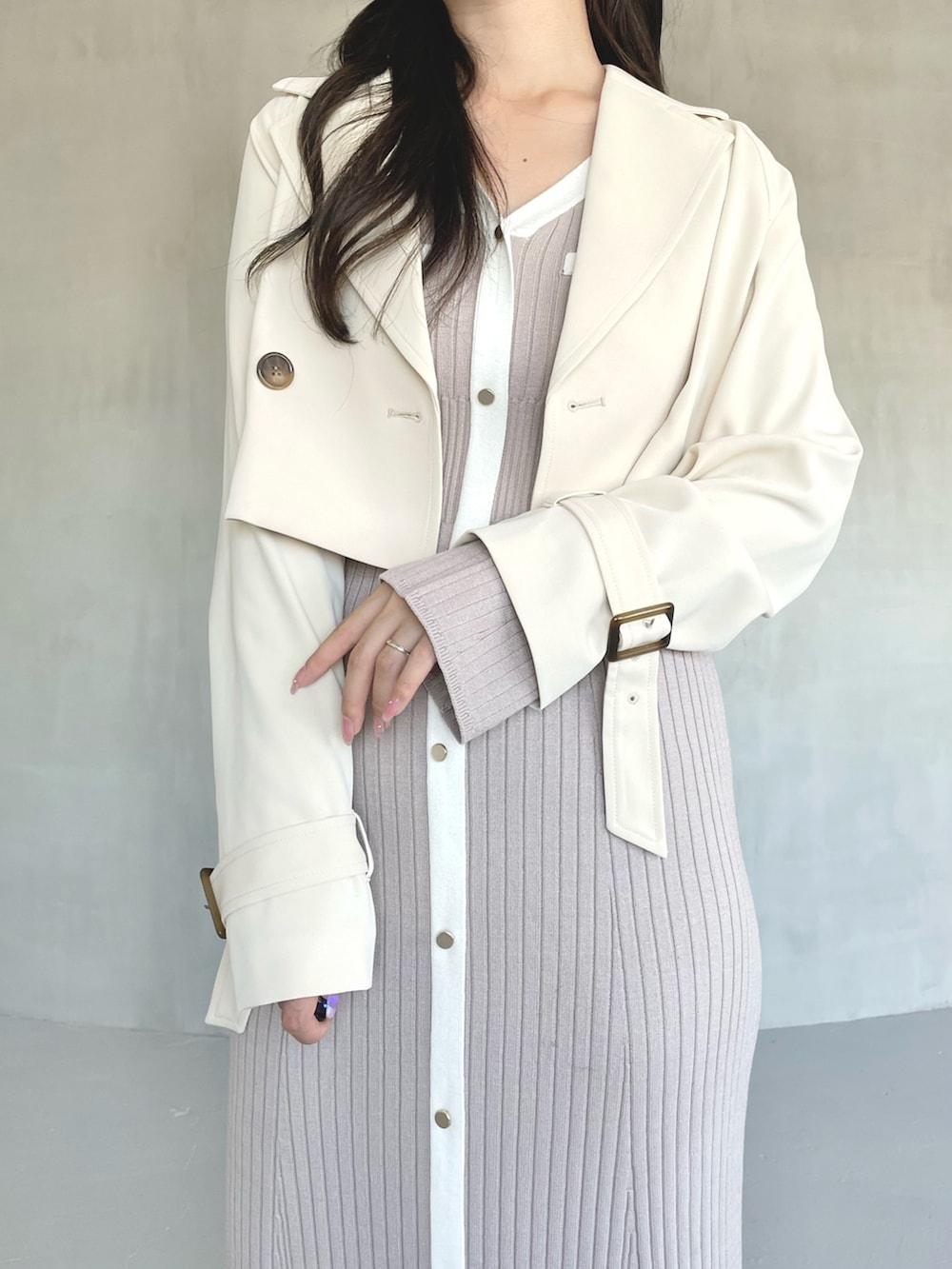 ベージュ系のトレンチコート、ピンク系のワンピース、ホワイト系のブーツを着用したレディースの冬コーディネートの3枚目の写真