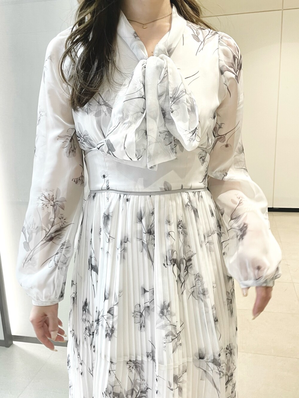 ホワイト系のワンピース、ブラック系のブーツを着用したレディースの冬コーディネートの4枚目の写真