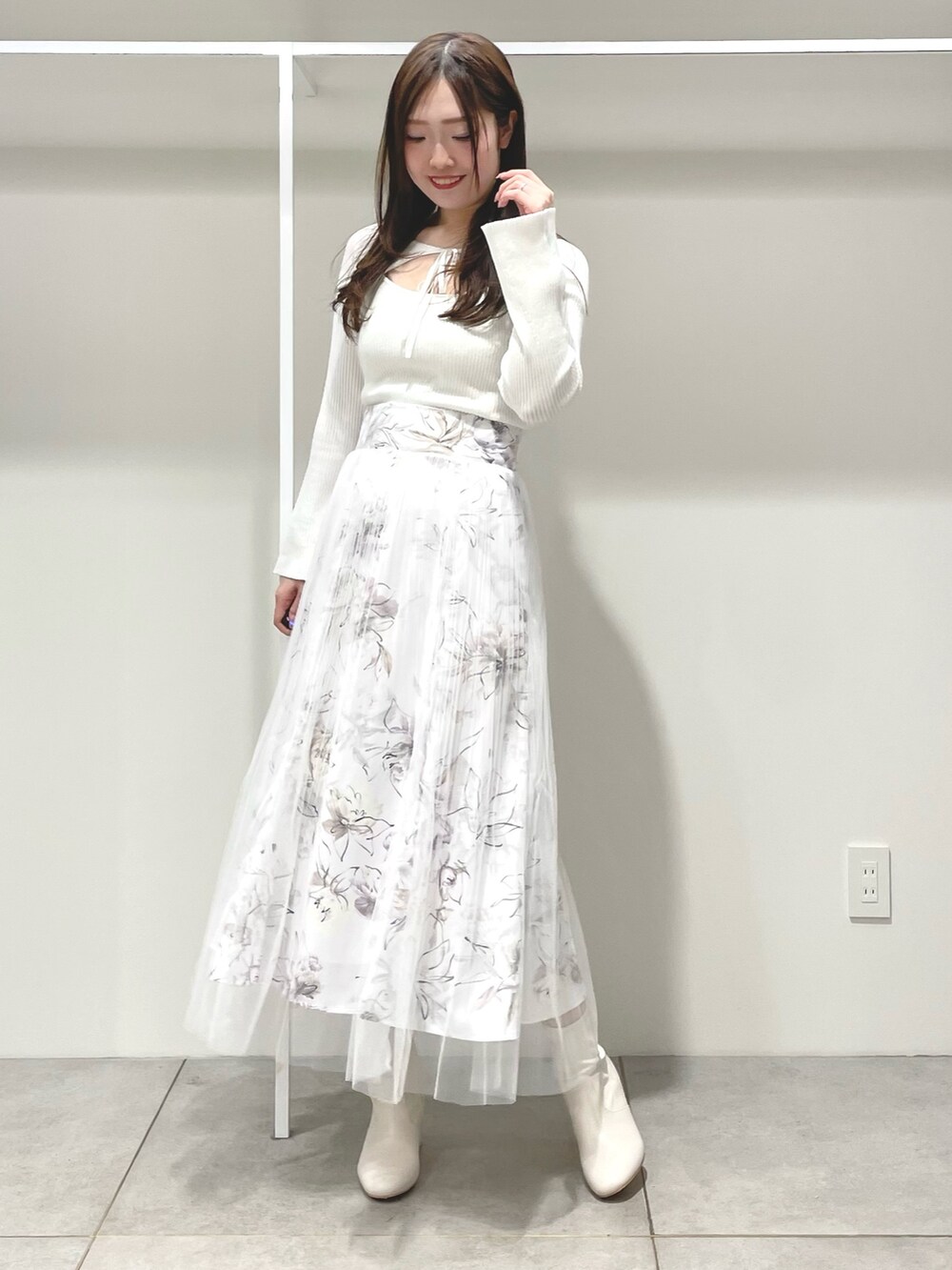 パープル系のトレンチコート、ホワイト系のニット/セーター、ピンク系のスカートを着用したレディースの春コーディネートの3枚目の写真