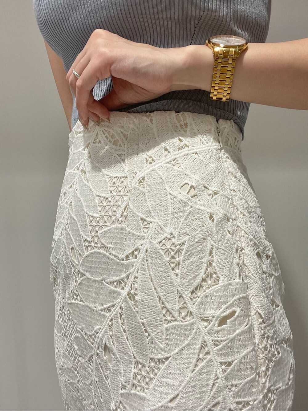 ホワイト系のスカート、ベージュ系のサンダル、ブルー系のニット/セーターを着用したレディースの夏コーディネートの6枚目の写真