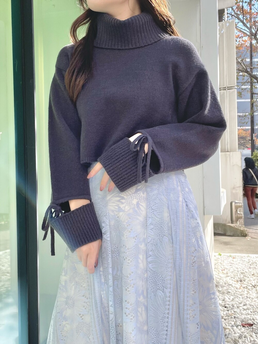 ブルー系のスカート、グレー系のニット/セーター、ブラック系のブーツを着用したレディースの冬コーディネートの6枚目の写真