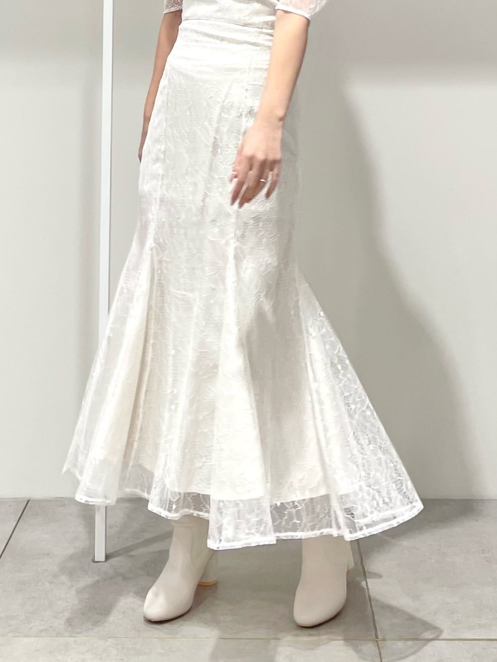 ホワイト系のシャツ/ブラウス、ホワイト系のスカート、ホワイト系のブーツを着用したレディースの冬コーディネートの7枚目の写真