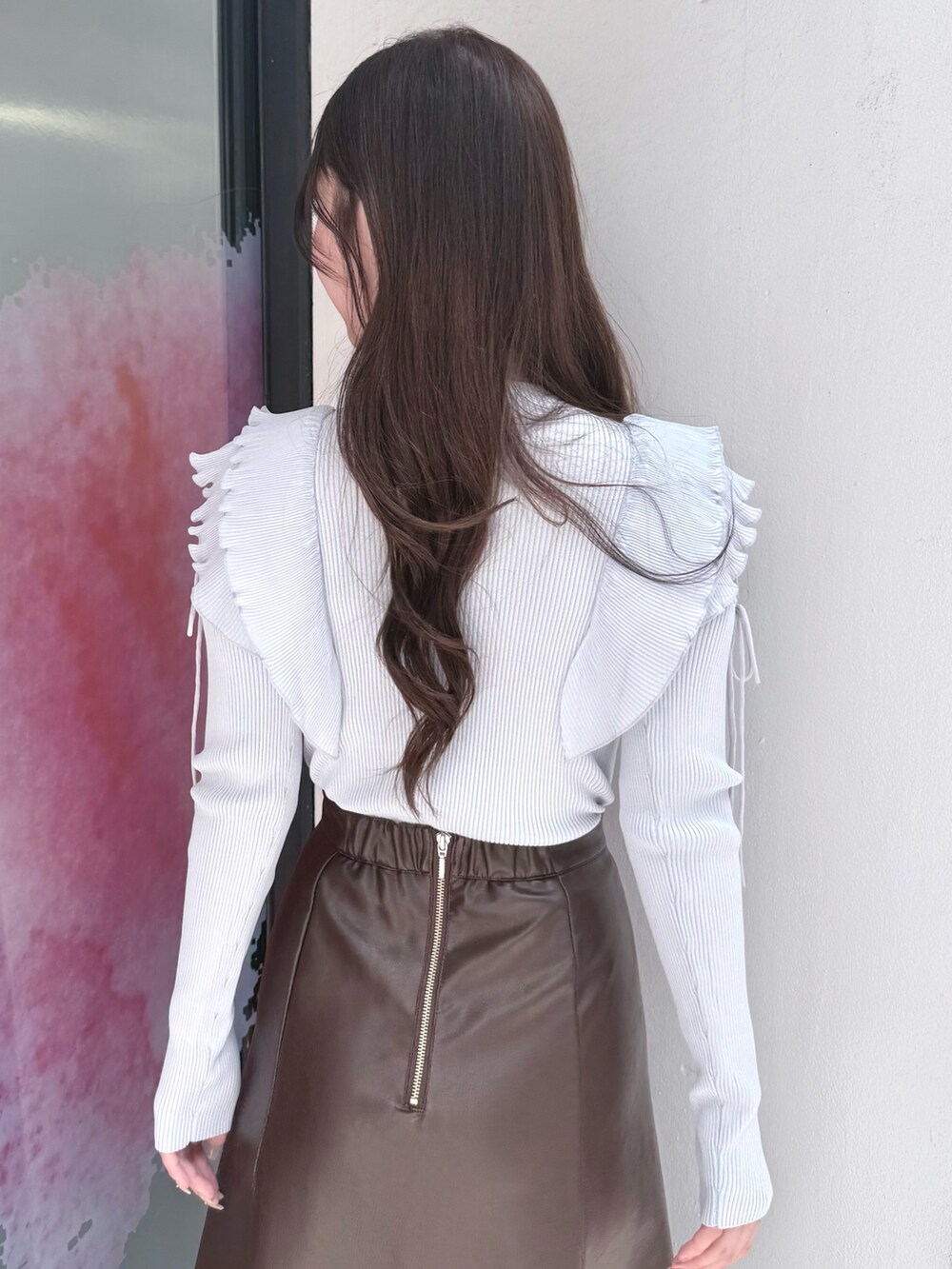 ブラウン系のスカート、ブルー系のニット/セーター、ブラック系のブーツを着用したレディースの秋コーディネートの7枚目の写真