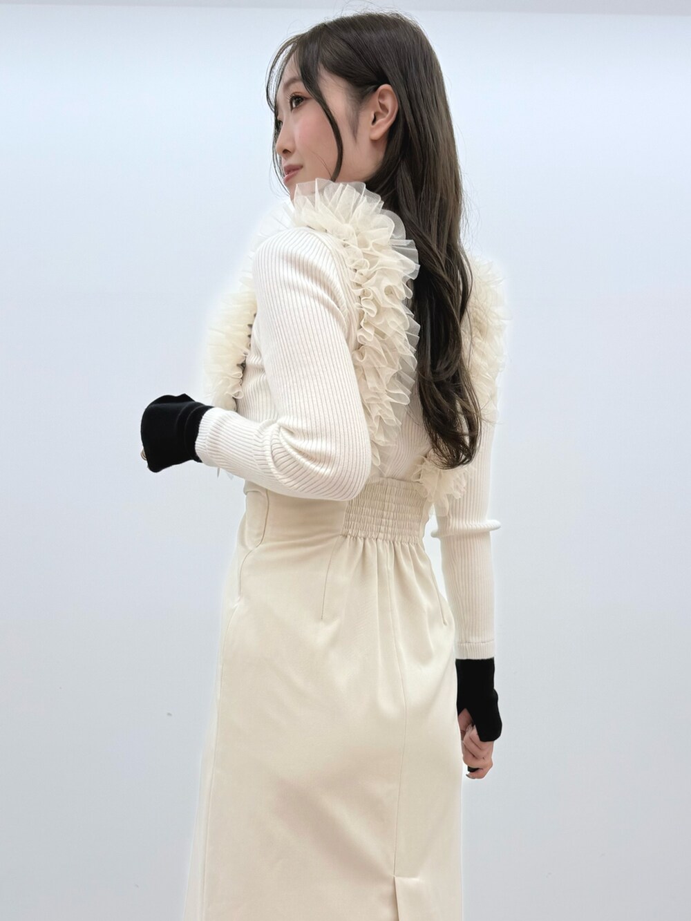 ホワイト系のスカート、ホワイト系のニット/セーター、ブラック系のブーツを着用したレディースの冬コーディネートの6枚目の写真