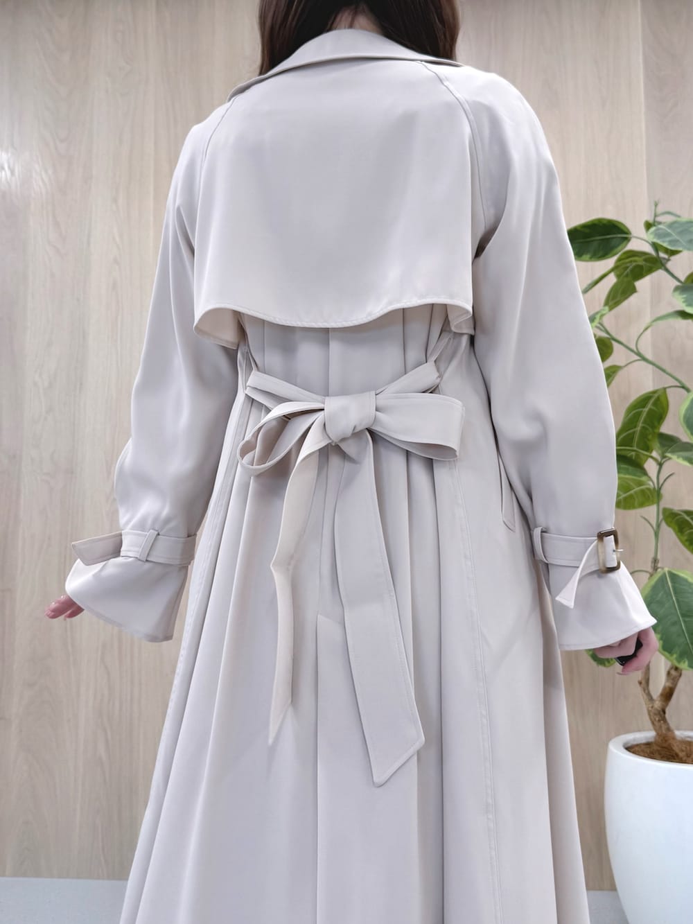 ホワイト系のトレンチコート、ピンク系のワンピース、ホワイト系のパンプスを着用したレディースの冬コーディネートの6枚目の写真