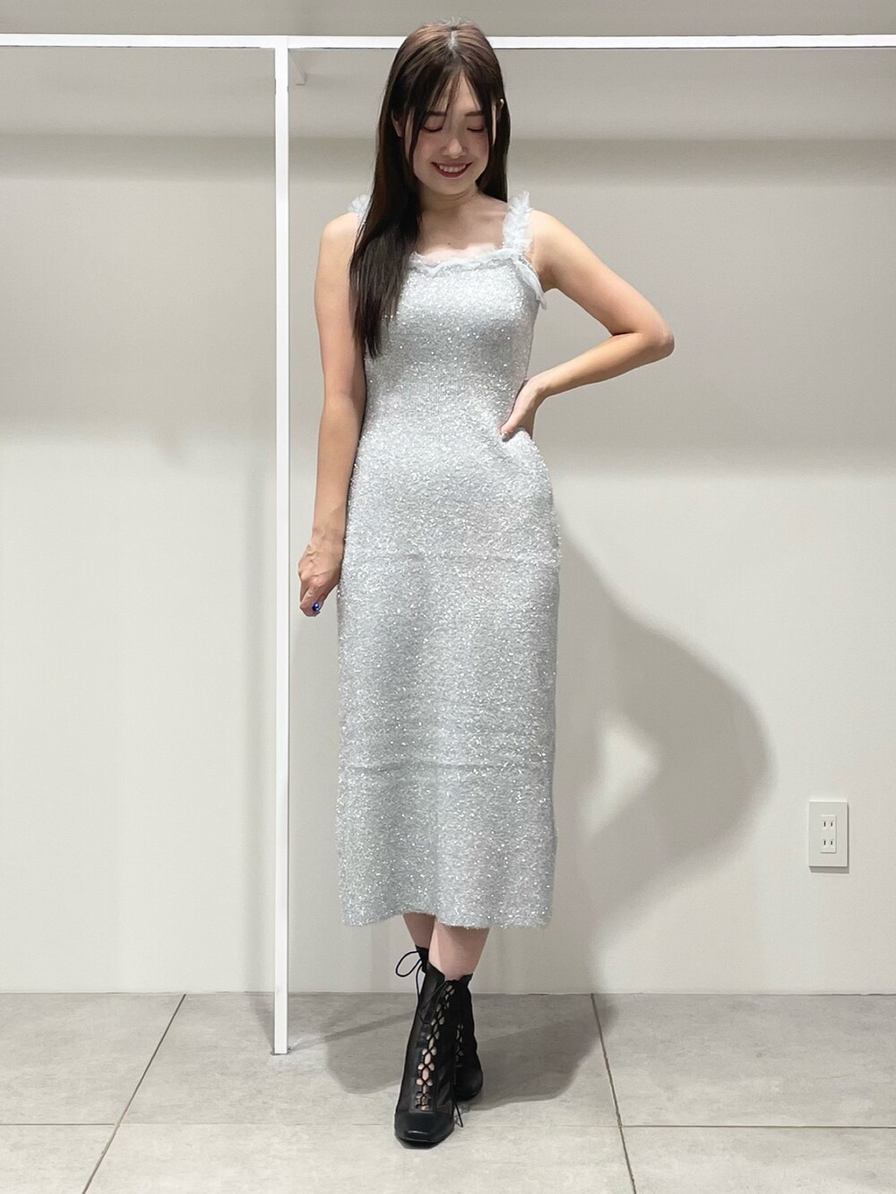 シルバー系のワンピース、ブラック系のショルダーバッグ、ブラック系のブーツを着用したレディースの秋コーディネートの7枚目の写真