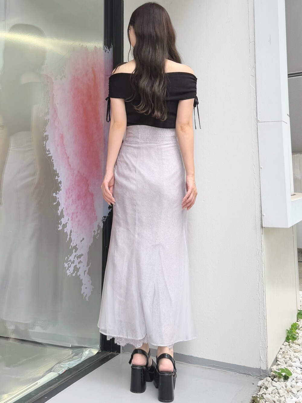 パープル系のスカート、ブラック系のニット/セーター、ブラック系のサンダルを着用したレディースの夏コーディネートの5枚目の写真