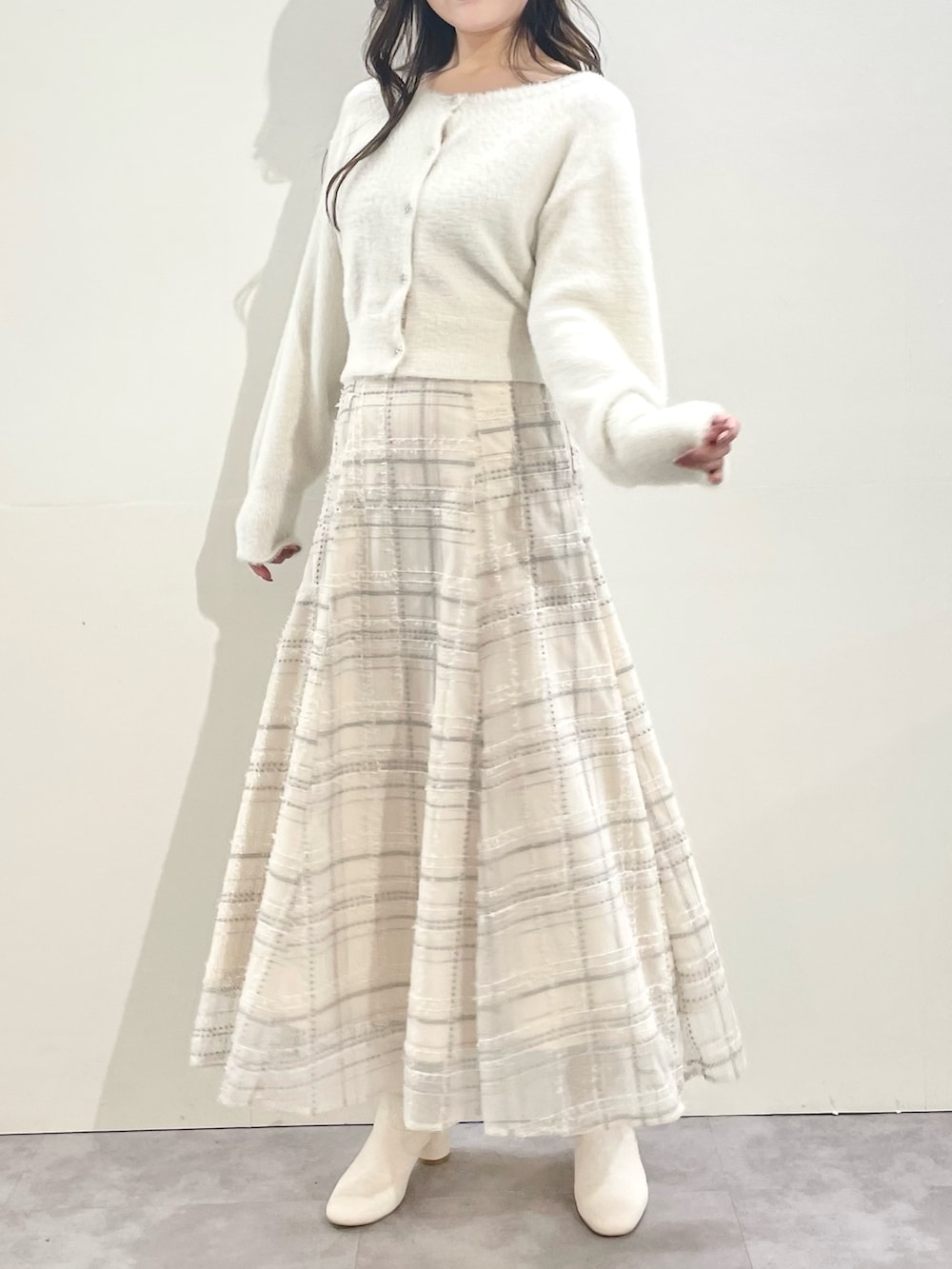 ホワイト系のその他アウター、ホワイト系のスカート、ホワイト系のブーツを着用したレディースの冬コーディネートの4枚目の写真