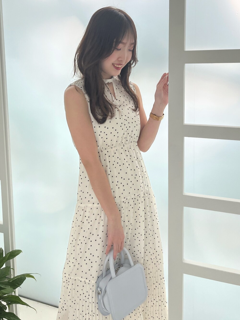 ホワイト系のワンピース、ブルー系のハンドバッグ、ホワイト系のサンダルを着用したレディースの夏コーディネートの5枚目の写真