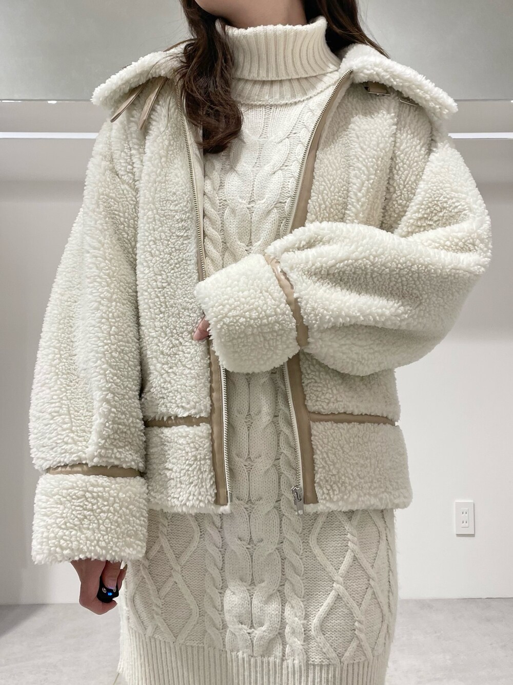 ホワイト系のその他アウター、ホワイト系のワンピース、ブラウン系のブーツを着用したレディースの冬コーディネートの4枚目の写真