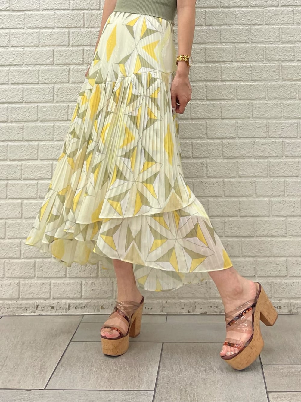 ベージュ系のサンダル、イエロー系のスカート、ベージュ系のニット/セーターを着用したレディースの夏コーディネートの4枚目の写真
