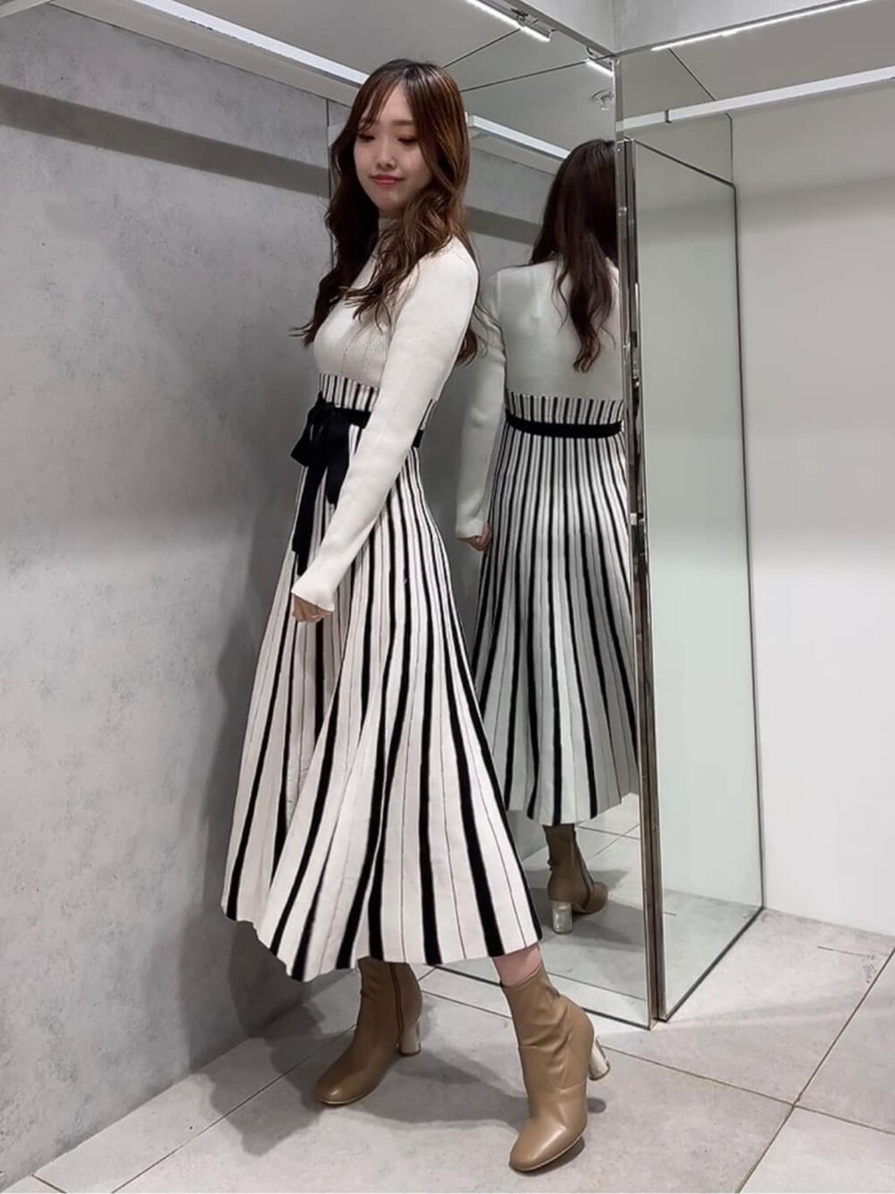 ベージュ系のトレンチコート、ベージュ系のトレンチコート、ホワイト系のワンピースを着用したレディースの秋コーディネートの5枚目の写真