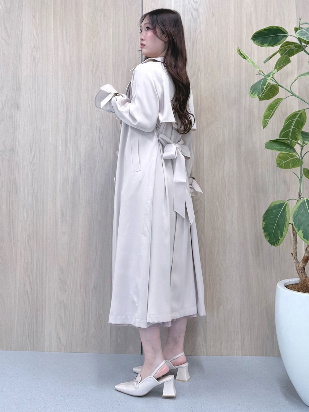 ホワイト系のトレンチコート、ピンク系のワンピース、ホワイト系のパンプスを着用したレディースの冬コーディネートの2枚目の写真