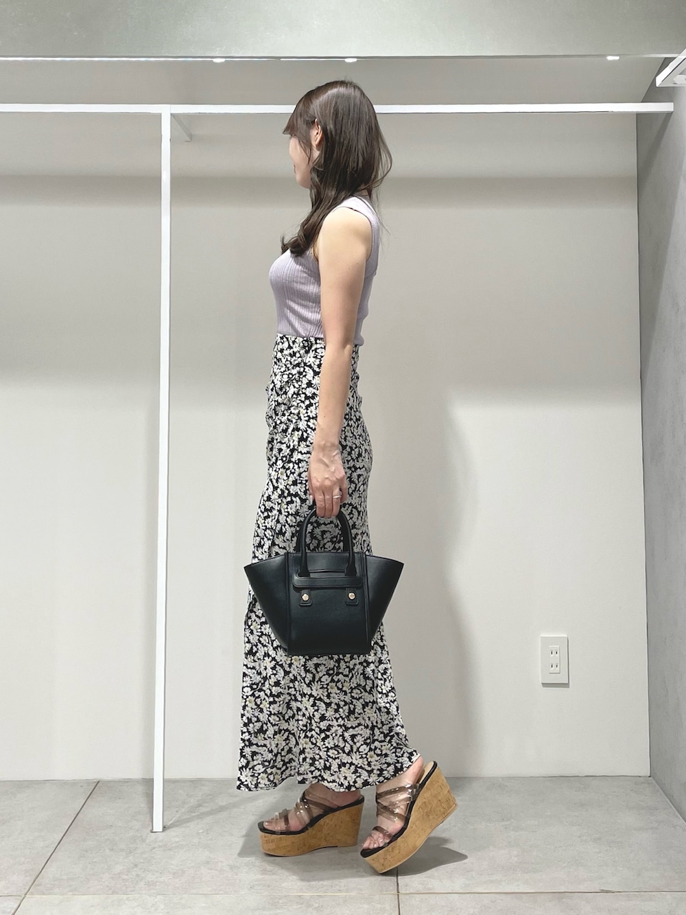 ブラック系のトートバッグ、ブラック系のスカート、ブラック系のサンダルを着用したレディースの夏コーディネートの2枚目の写真