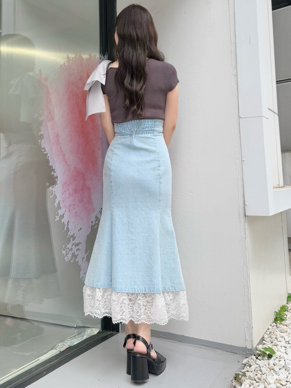 ブルー系のスカート、グレー系のニット/セーター、ブラック系のサンダルを着用したレディースの夏コーディネートの4枚目の写真