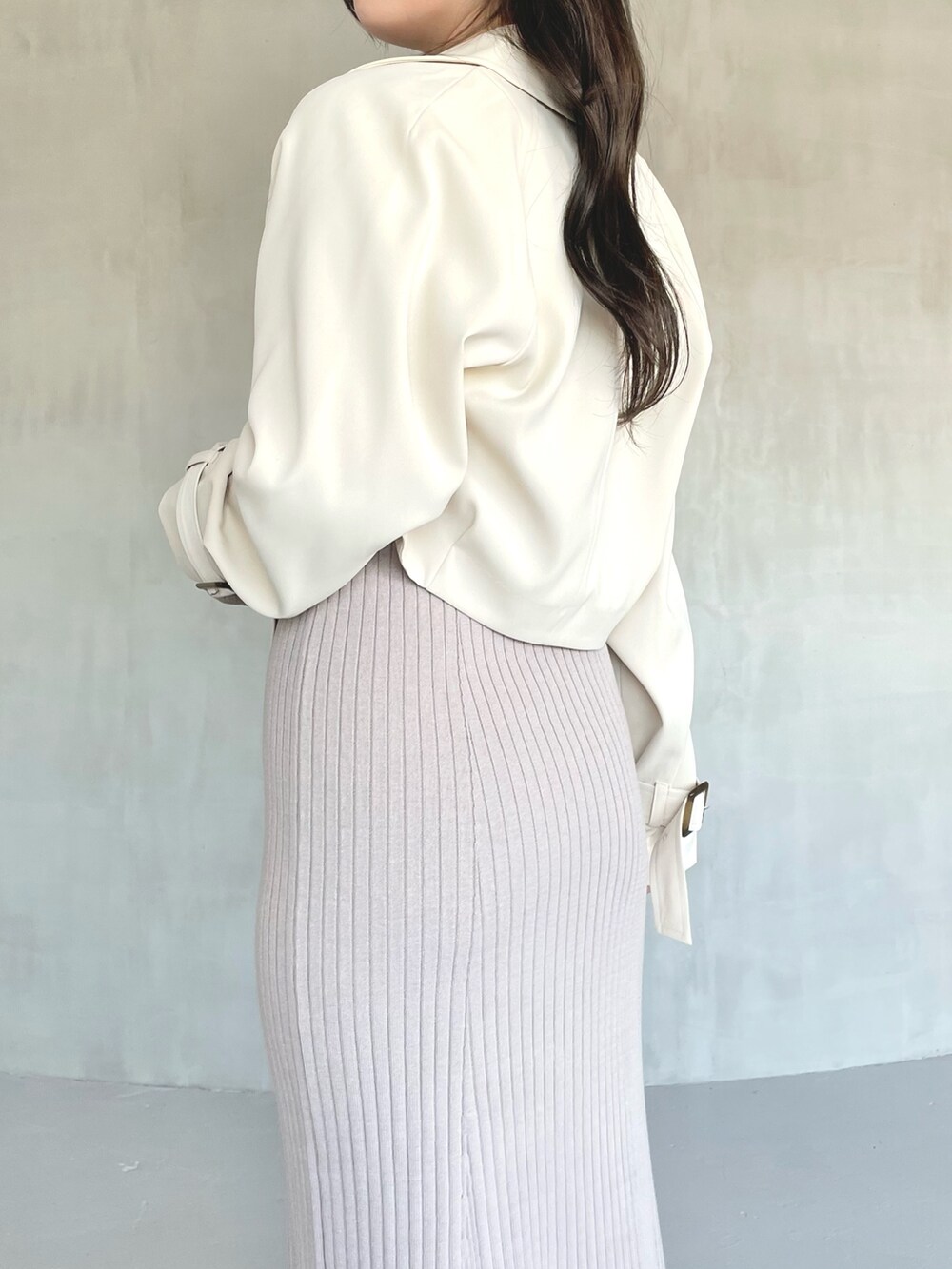 ベージュ系のトレンチコート、ピンク系のワンピース、ホワイト系のブーツを着用したレディースの冬コーディネートの4枚目の写真