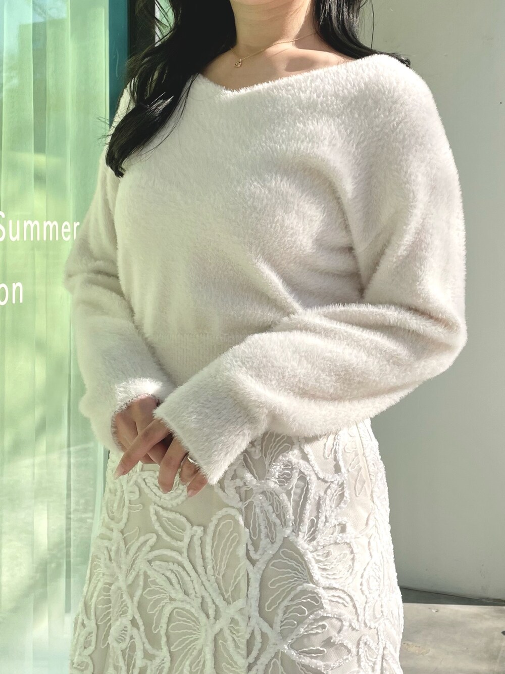 ホワイト系のダウンジャケット/コート、ホワイト系のニット/セーター、ホワイト系のスカートを着用したレディースの冬コーディネートの7枚目の写真