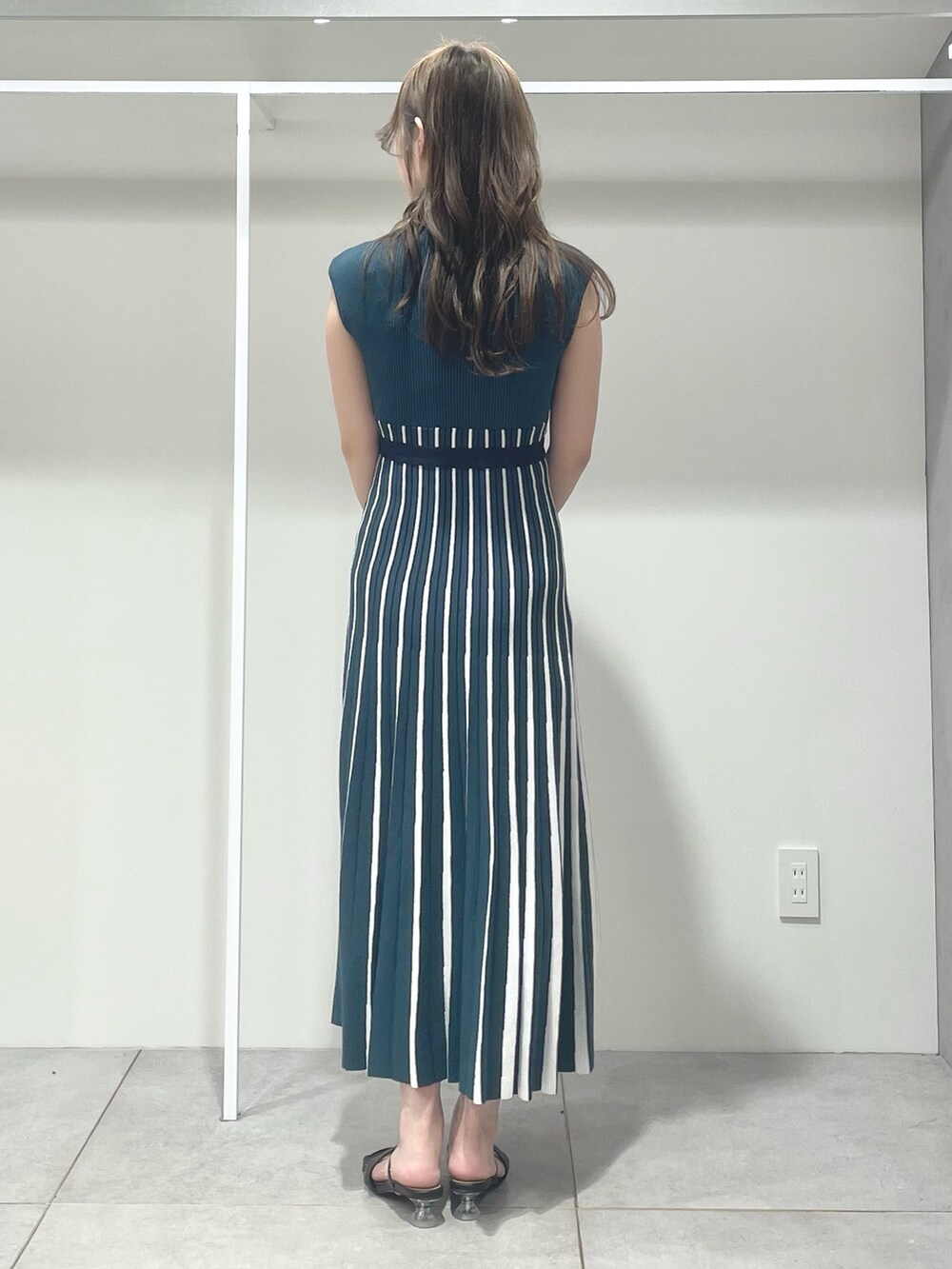 ブラック系のトートバッグ、ブラック系のサンダル、グリーン系のワンピースを着用したレディースの夏コーディネートの3枚目の写真