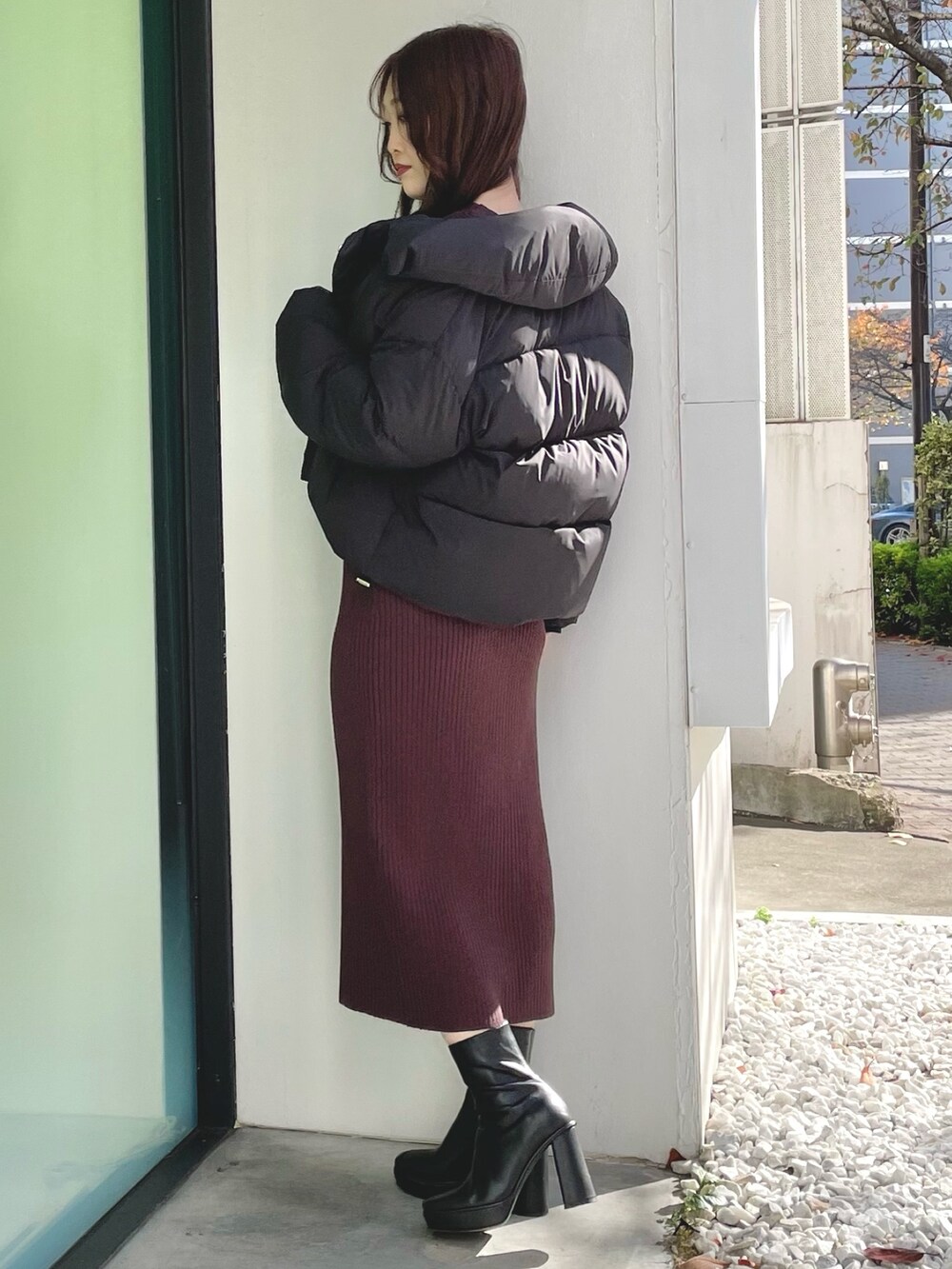 ブラック系のダウンジャケット/コート、ブラウン系のワンピース、ブラック系のブーツを着用したレディースの冬コーディネートの2枚目の写真