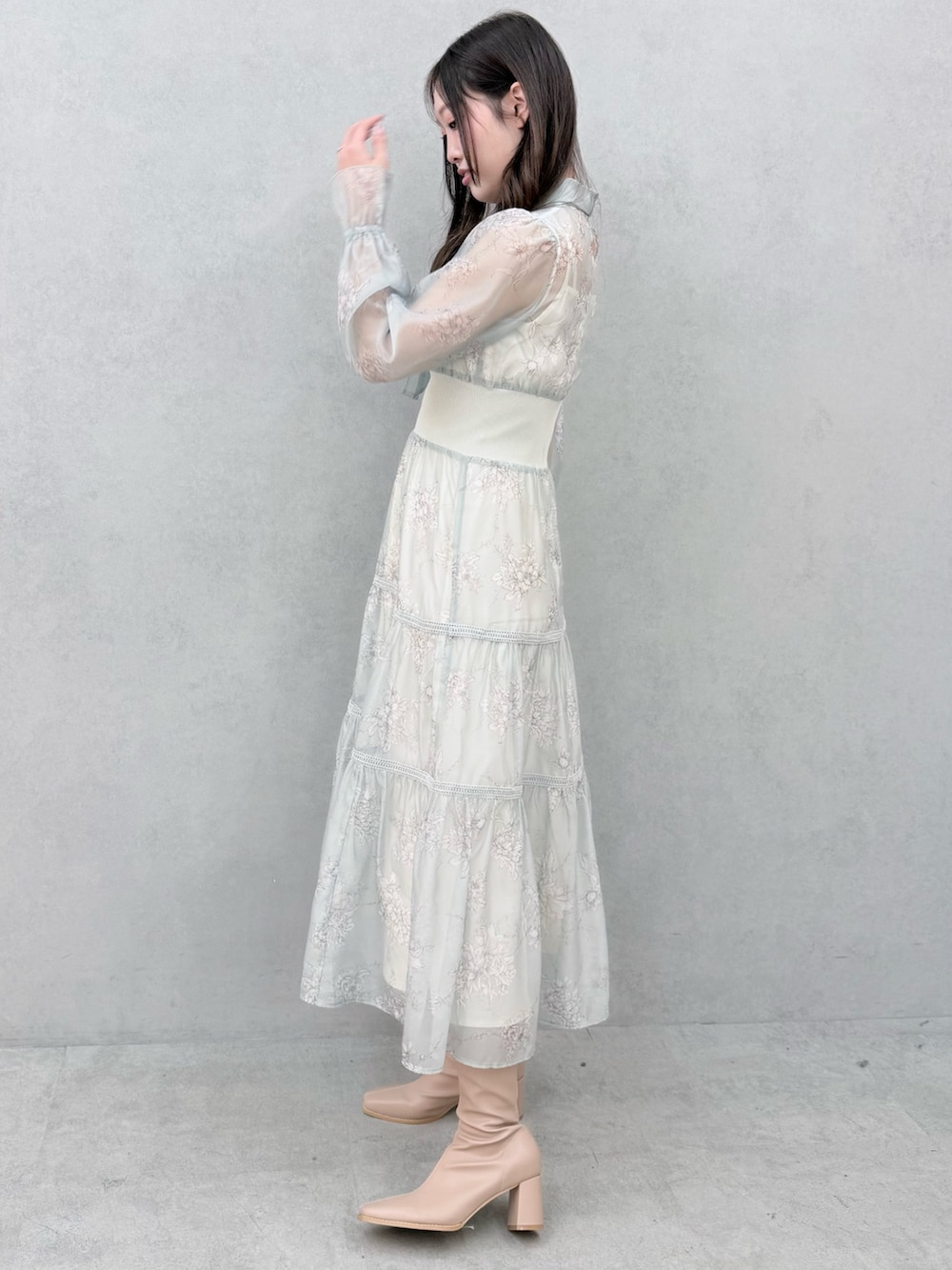 グリーン系のワンピース、ベージュ系のブーツを着用したレディースの冬コーディネートの2枚目の写真