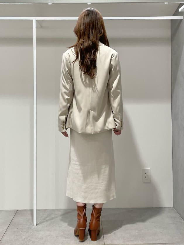 ブラウン系のブーツ、ベージュ系のテーラードジャケット、ホワイト系のワンピースを着用したレディースの秋コーディネートの6枚目の写真