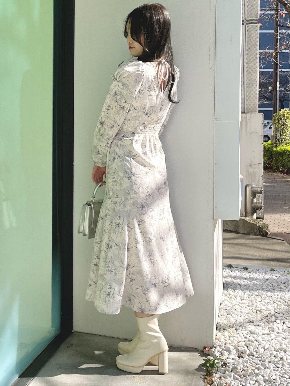 シルバー系のハンドバッグ、ホワイト系のブーツ、ホワイト系のチェスターコートを着用したレディースの冬コーディネートの7枚目の写真