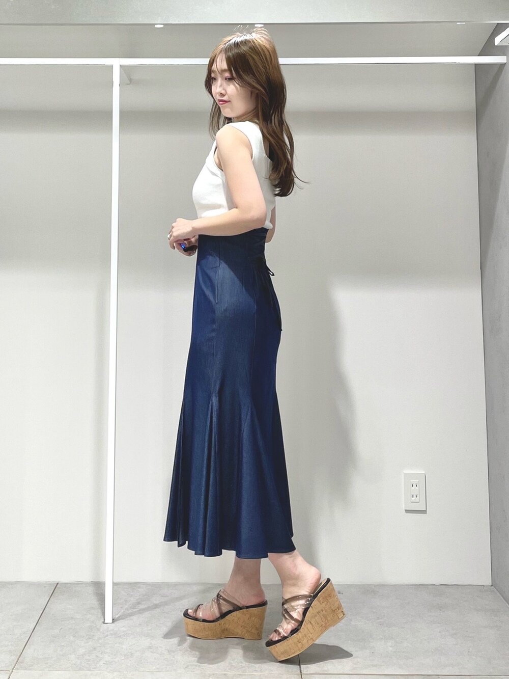 ブルー系のスカート、ブラック系のサンダル、ベージュ系のシャツ/ブラウスを着用したレディースの春コーディネートの7枚目の写真