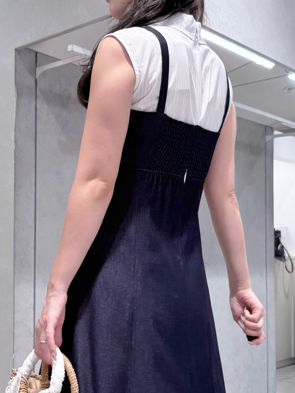 ブルー系のワンピース、ベージュ系のハンドバッグ、ホワイト系のサンダルを着用したレディースの夏コーディネートの5枚目の写真