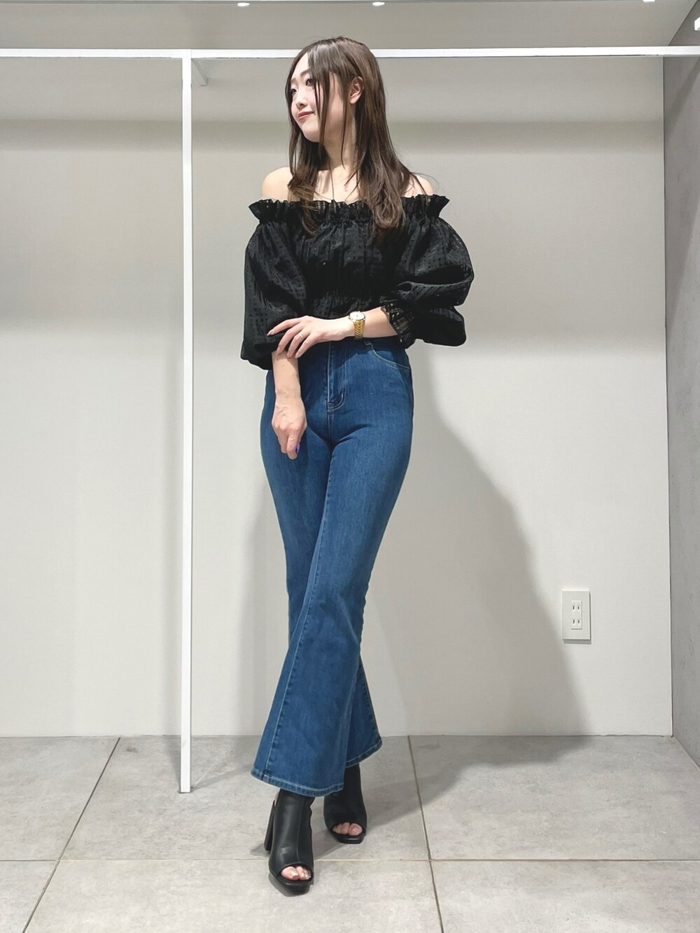 ブルー系のトレンチコート、ブルー系のデニムパンツ、ブラック系のブーツを着用したレディースの春コーディネートの5枚目の写真