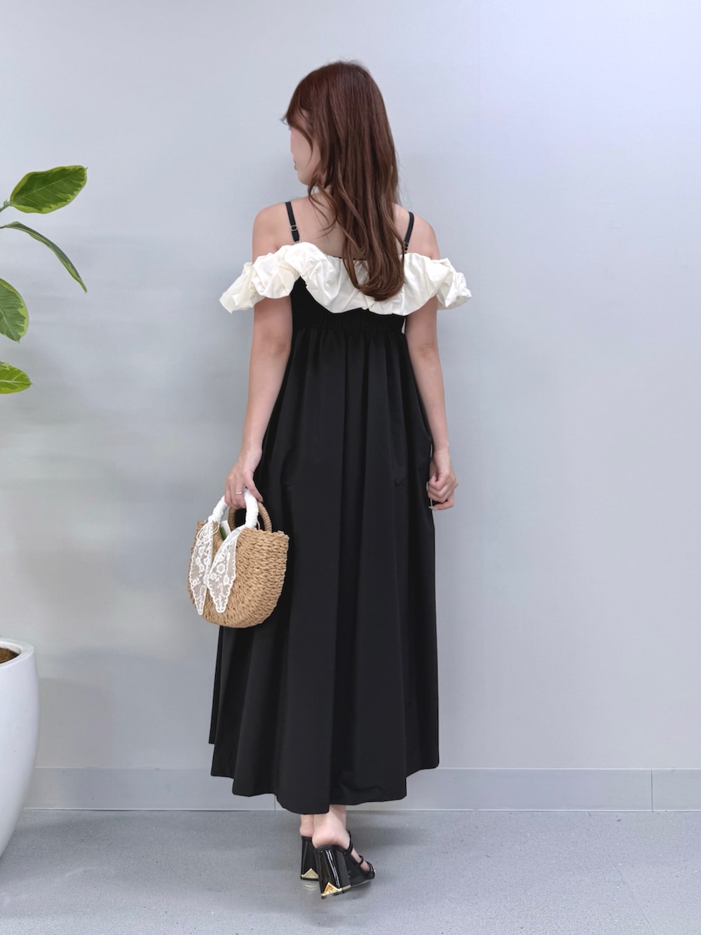 ブラック系のワンピース、ベージュ系のハンドバッグ、ブラック系のサンダルを着用したレディースの夏コーディネートの4枚目の写真