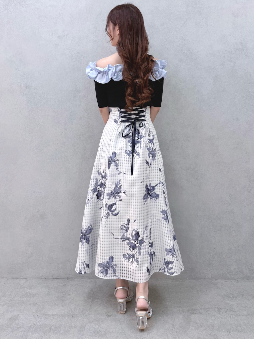 ブルー系のニット/セーター、ブルー系のスカート、シルバー系のサンダルを着用したレディースの春コーディネートの3枚目の写真