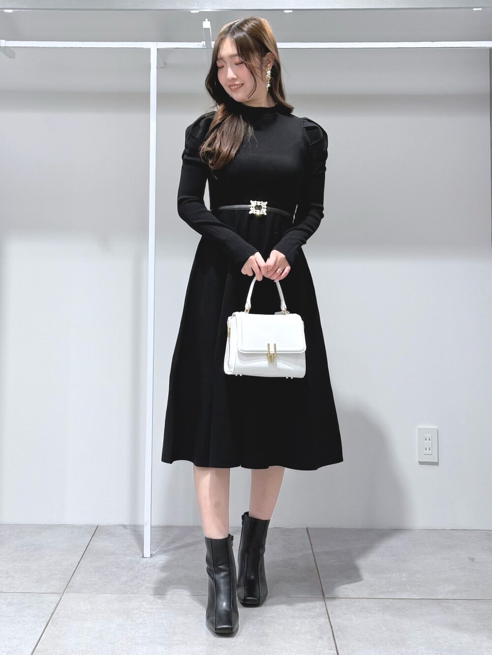ベージュ系のその他アウター、ホワイト系のハンドバッグ、ブラック系のワンピースを着用したレディースの冬コーディネートの7枚目の写真