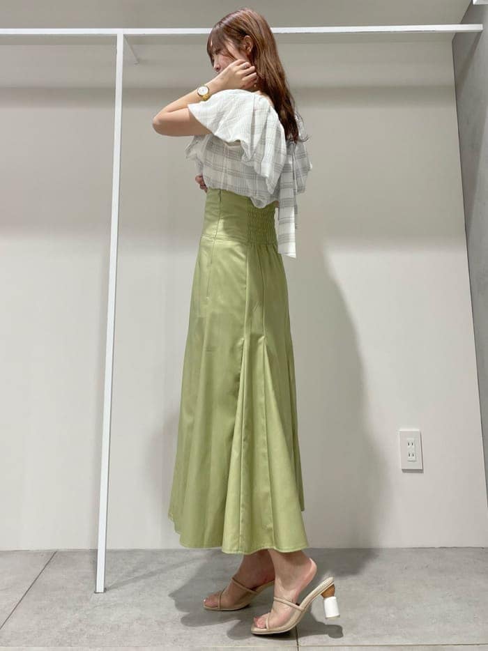 ホワイト系のキャミソール、グリーン系のスカート、ベージュ系のサンダルを着用したレディースの夏コーディネートの2枚目の写真