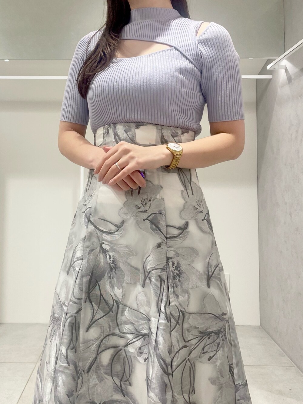 シルバー系のハンドバッグ、ホワイト系のテーラードジャケット、ブルー系のニット/セーターを着用したレディースの春コーディネートの8枚目の写真